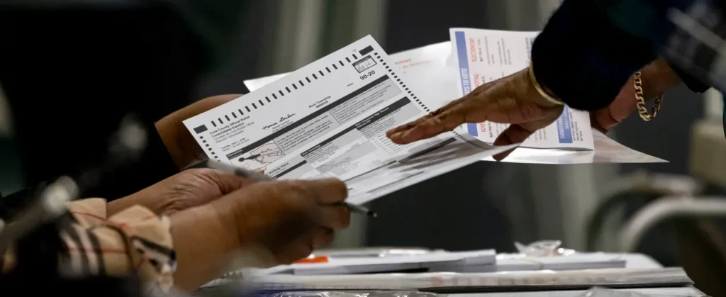 A voter receives a ballot on April 1, 2025, in the suburban Cook County Consolidated Election at Yates Elementary School in Matteson
